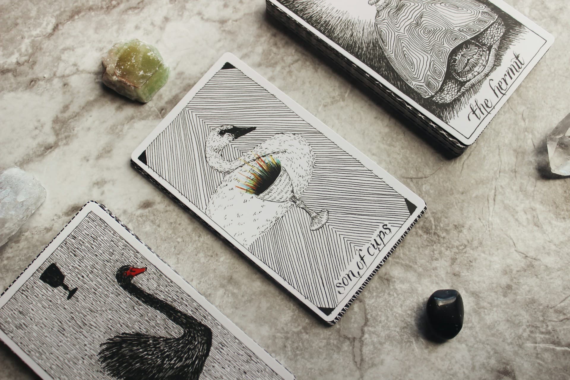 Tarot cards displayed with crystals on a stone table, representing tarot reading.