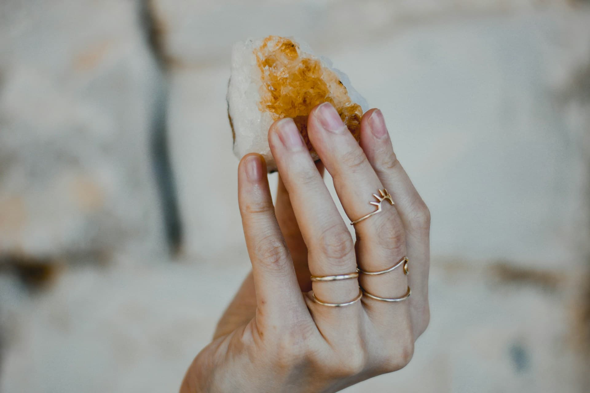 A hand holding a yellow crystal, symbolizing angel healing.